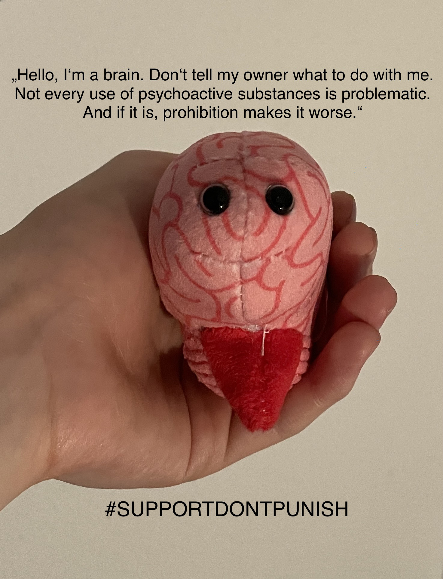 Graphik mit einem kleinen Stoff-Hirn in einer Hand und dem Text auf Englisch: "Hello, I'm a brain. Don't tell my owner what to do with me. Not every use of psychoactive substances is problematic. And if it is, prohibition makes it worse." und dem Hashtag "Support Dont Punish". Übersetzung in der Bildunterschrift.