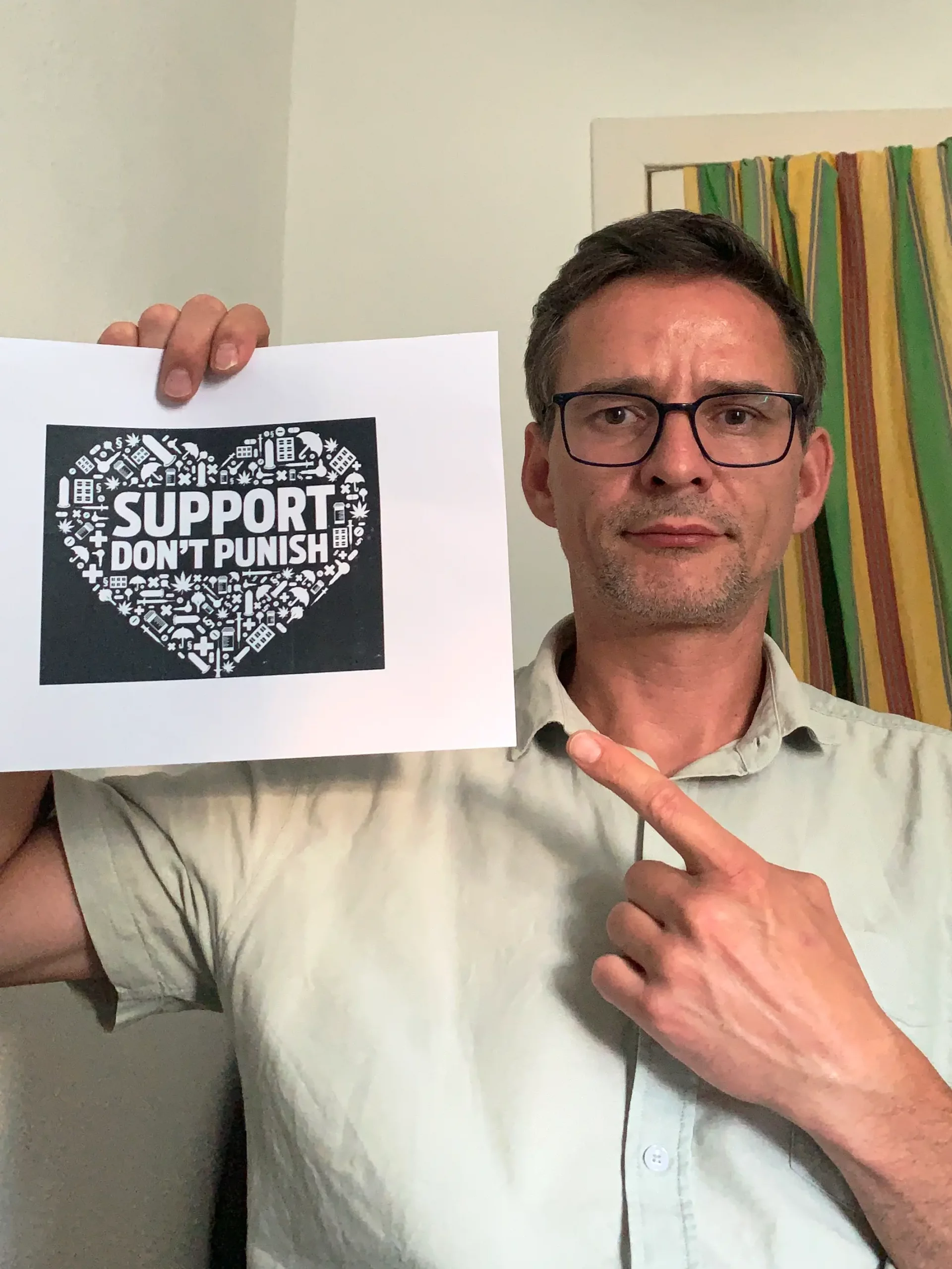 Selfie von Karsten Keller mit dem ausgedruckten Logo "Support Dont Punish" in Herzform