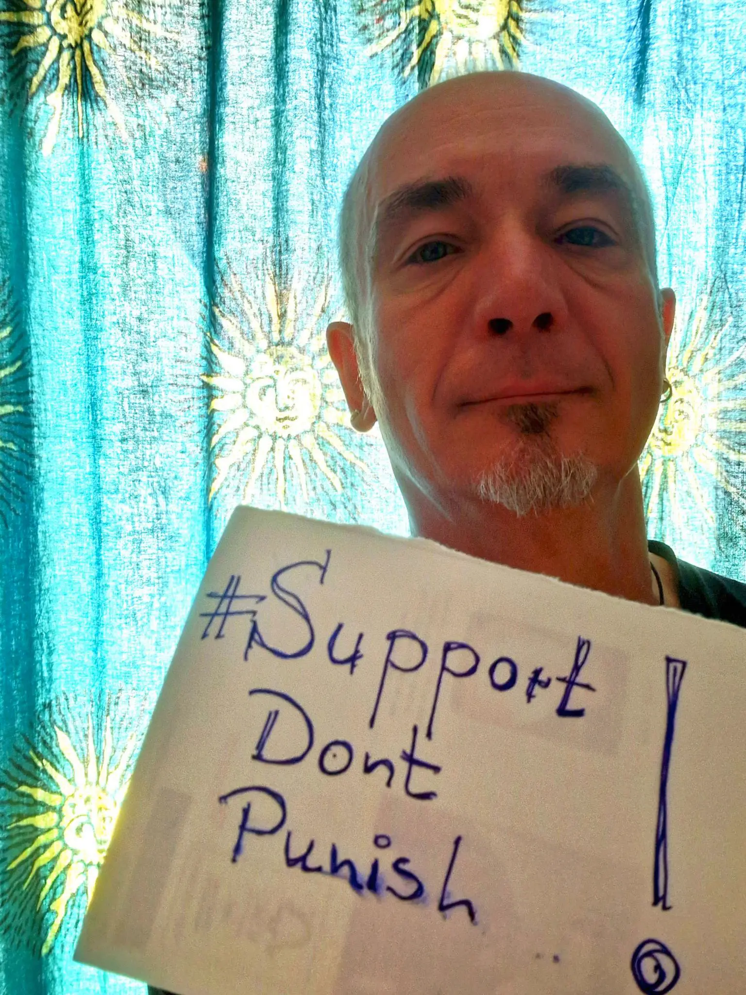 Selfie mit einem Schild mit der Handschrift "Support Dont Punish"