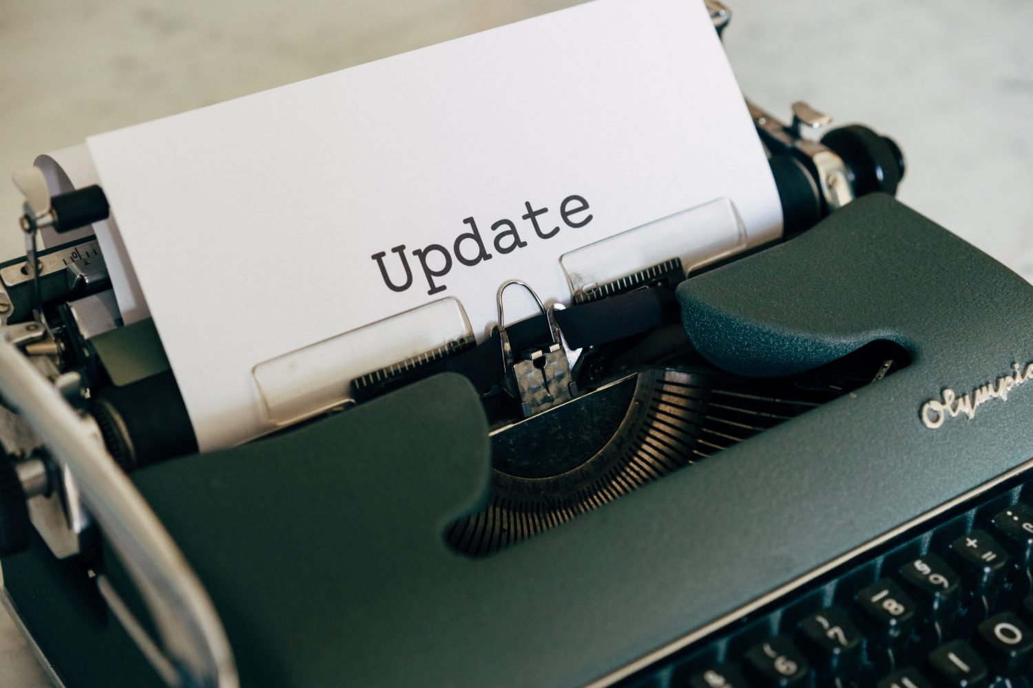 Eine schöne Schreibmaschine mit einem eingespanntem Blatt, auf dem das Wort "Update" steht.